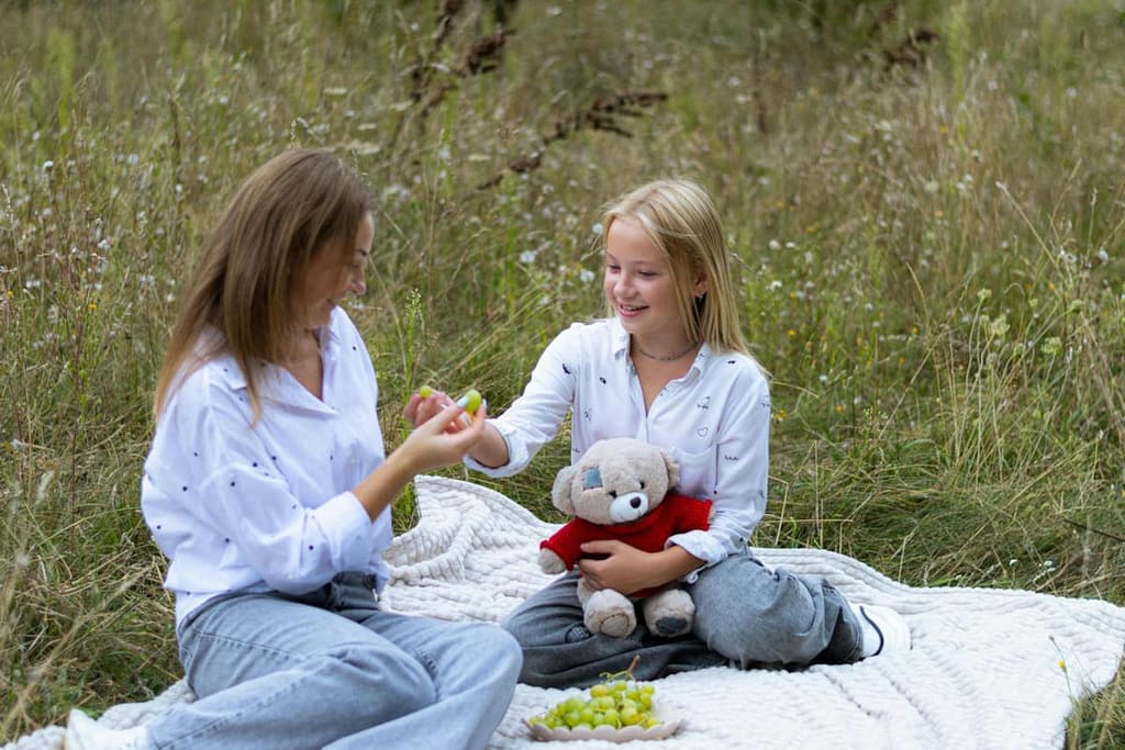 A Mom and daughter enjoying a picnic, eating grapes, and talking about the fruit of the Spirit Love.