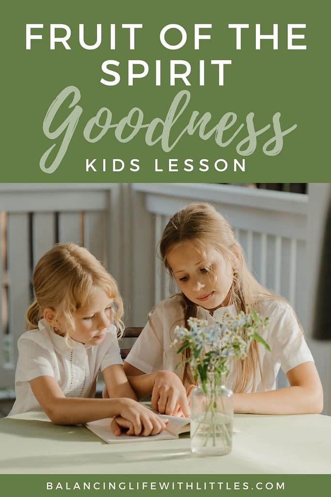 A Pinterest pin with a title that reads: Fruit of the Spirit Goodness Kids Lesson. It includes a picture of an older sister demonstrating the Fruit of the Spirit Goodness by helping her younger sister read while sitting at a table on a patio.